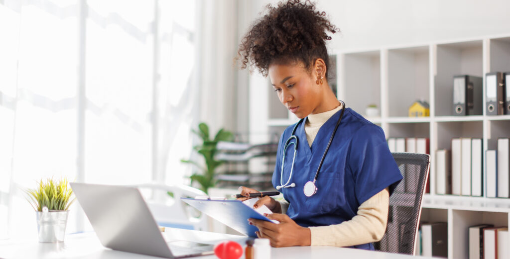 A clinician working at a wall-sized display of scans and patient data