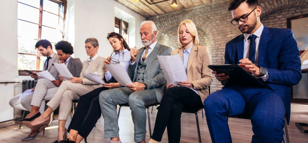 Candidates waiting in a row with folders and CVs before an interview