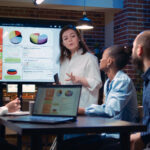 Colleagues reviewing charts on a wall display during a working session
