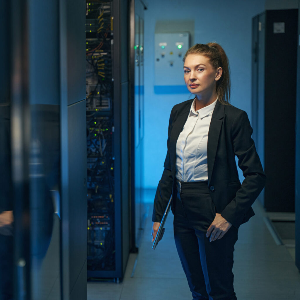 An engineer walking a data centre aisle between server racks